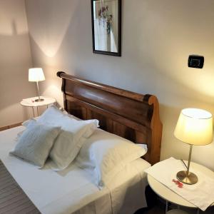 een bed met witte lakens en kussens in een kamer bij Stella d'Italia in Sparone