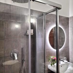 een badkamer met een douche, een wastafel en een spiegel bij Stella d'Italia in Sparone