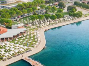 Grand Hotel Portoroz 4* superior – Terme & Wellness LifeClass في بوروتوروج: اطلالة جوية على المسبح مع الكراسي والمظلات