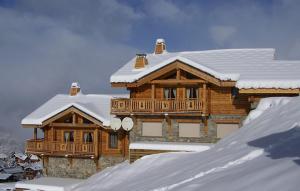 una gran casa de madera con nieve en el techo en Odalys Chalet Leslie Alpen 2 en Les Deux Alpes