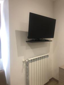 a flat screen tv on a wall next to a radiator at Sweet home in Isnello