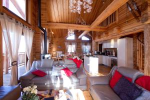 a living room with couches and a kitchen in a cabin at Odalys Chalet Leslie Alpen 2 in Les Deux Alpes