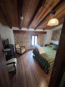 um quarto com uma cama e uma parede de pedra em La Garbinada Hotel em Grañena de las Garrigas