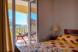 a bedroom with a bed and a balcony with a view at Apartments Mladenka in Orebić