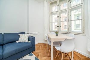 salon z niebieską kanapą i stołem w obiekcie Cozy apartment in hipster area w Pradze