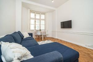 a living room with a blue couch and a tv at Cozy apartment in hipster area in Prague