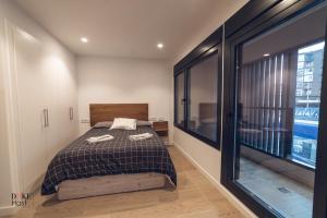 a bedroom with a bed and a large window at Castilla Luxury 1B Apartment in Madrid
