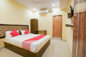 1 dormitorio con 1 cama con almohadas rojas y TV en OYO R Square Stay Near LB Nagar Metro, en Surūrnagar