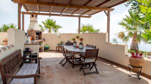 a patio with a table and chairs and a fence at B&B El Pajarero in Arenas