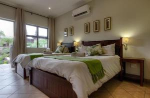 1 dormitorio con 2 camas y ventana grande en Forest Lodge, en St Lucia