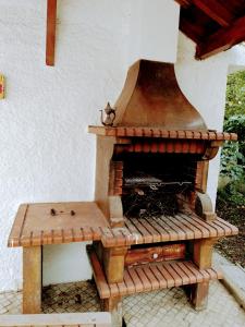 an outdoor pizza oven with a bench next to it at Casa dos Quatro Irmãos in Gouveia
