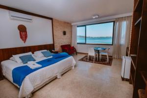 a bedroom with a bed and a view of the ocean at Partner Itapoa by Marina in Itapoa