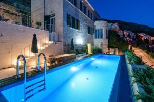 una piscina frente a un edificio en Villa Grande Bukovca - Beautiful 5 bedroom villa - Sea views - Glamorous location en Dubrovnik