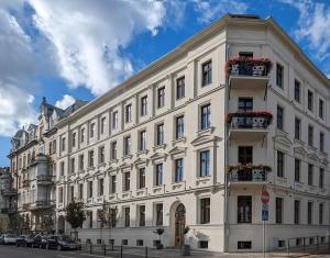 a large white building with flowers on the balconies at Apartamenty Strzelecka 34 in Poznań