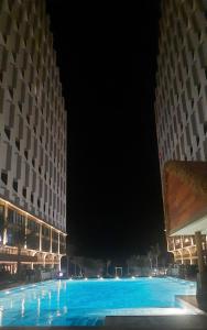 a large swimming pool at night with two buildings at Apec Mandala Mũi Né in Ấp Long Sơn