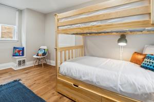 匹茲堡的住宿－Charming Remodeled 3-BR Bungalow near Attractions，一间卧室配有双层床,铺有木地板