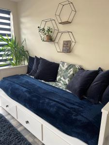 uma cama num quarto com lençóis e almofadas azuis em Luxury stay Kings Annexe 5 minutes from Longleat em Warminster