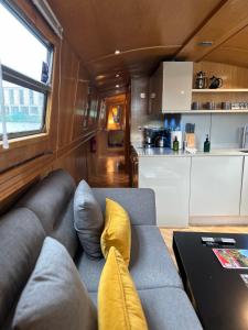 a living room with a couch and a table at The Four Sisters Boatel - Houseboat in Edinburgh