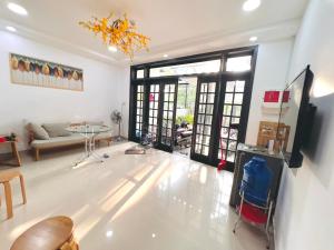 ein Wohnzimmer mit einer Couch und einem Kronleuchter in der Unterkunft KENPI Homestay in Hue