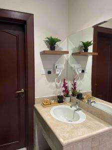 a bathroom with a sink and a mirror at شقة عصرية واسعة بغرفتي نوم موقع مميز وسط المدينة in Riyadh