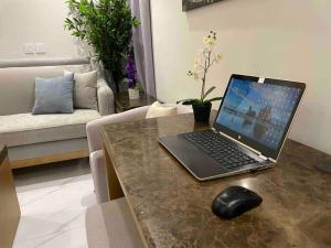 a laptop computer sitting on a table in a living room at شقة عصرية واسعة بغرفتي نوم موقع مميز وسط المدينة in Riyadh