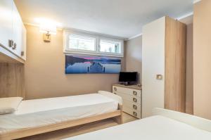 a small bedroom with two beds and a tv at Golfo dei Poeti! Tellaro Holiday Home in Tellaro