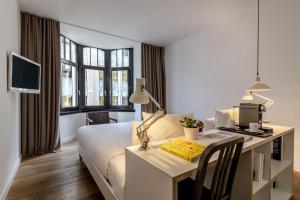 una camera d'albergo con letto e scrivania con computer di 9Hotel Central a Bruxelles