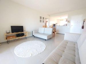 a living room with a couch and a tv at Apartamento no Villa das Águas in Estância