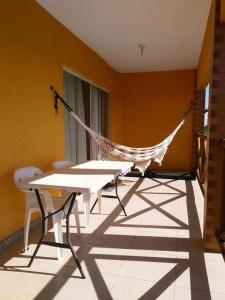 a hammock in a room with a table and chairs at Apartamento no Villa das Águas in Estância