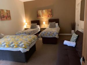 a room with two beds and a couch at Broadwalk_2 in Coltishall