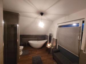 a bathroom with a tub and a toilet and a sink at Hannover Fair Retreat in Laatzen