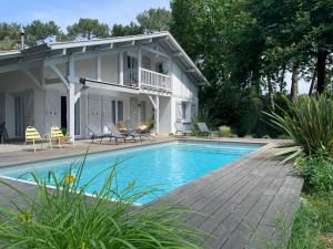 een huis met een zwembad ervoor bij Villa "OSTAU OCÉANE" in Capbreton