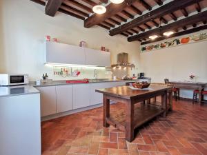 una grande cucina con tavolo in legno in una stanza di Villa Val di Luce - Homelike Villas a Umbertide