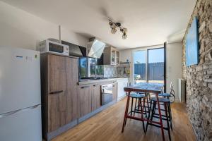 eine Küche mit Tisch und Kühlschrank in der Unterkunft Le Cottage de Flore - Avec piscine privée chauffée in Saint-Jean-la-Poterie + 11 Fotos