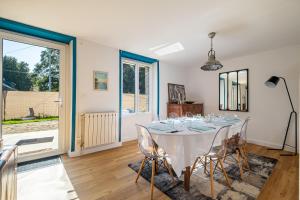comedor con mesa blanca y sillas en Le Cottage de Flore - Avec piscine privée chauffée en Saint-Jean-la-Poterie