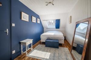 Habitación pequeña con cama y espejo. en Le Cottage de Flore - Avec piscine privée chauffée en Saint-Jean-la-Poterie