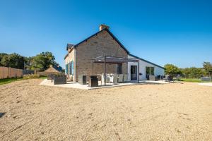 ein Gebäude mit einem Schutzraum neben einem Feldfeld in der Unterkunft Le Cottage de Flore - Avec piscine privée chauffée in Saint-Jean-la-Poterie