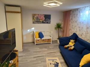 a living room with a teddy bear sitting on a blue couch at 60 m² Ferienapartment Zentrumsnahe mit Gartenbenutzung in Steyr