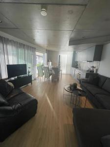 a living room with a couch and a table at Panoramaresort in Hardangerfjorden With boat to rent - leilighet i sjøkanten ved Hardangerfjorden for 7 personer NEW sauna from desember 2023 in Øystese