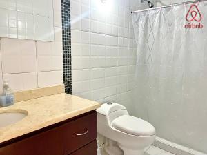 a bathroom with a toilet and a sink and a shower at A 5 minutos de Aeropuerto Dorado in Bogotá +11 photos