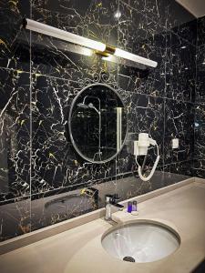 W łazience znajduje się umywalka i lustro. w obiekcie hi HOTEL IVY BÜYÜKADA w mieście Adalar