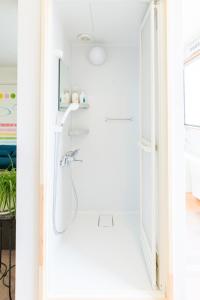 uma casa de banho com um chuveiro num quarto branco em GUEST HOUSE BLUE DOORS - Vacation STAY 73130v em Yamagata