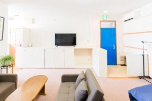 sala de estar con sofá y TV en GUEST HOUSE BLUE DOORS - Vacation STAY 73130v, en Yamagata