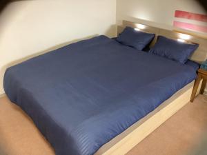 1 dormitorio con cama azul y almohadas azules en GUEST HOUSE BLUE DOORS - Vacation STAY 73130v, en Yamagata