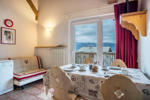 uma sala de jantar com uma mesa e uma janela em Giongo Residence Aparthotel 104 em Lavarone