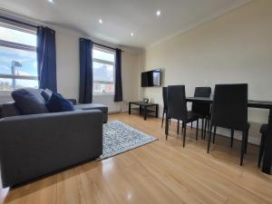a living room with a couch and a table and chairs at Tooting Bec Central Apartment by London Tube in London
