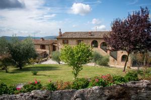 una casa in pietra con un giardino di fronte di Villa Val di Luce - Homelike Villas a Umbertide