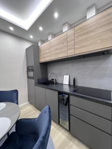 a kitchen with a counter and two chairs and a table at Anna Elite in Debrecen