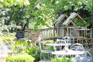 a garden with tables and chairs and a bird house at Harrington House in Hilton