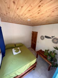 a bedroom with a green bed and a wooden ceiling at Casa de la playa in Santa Catalina